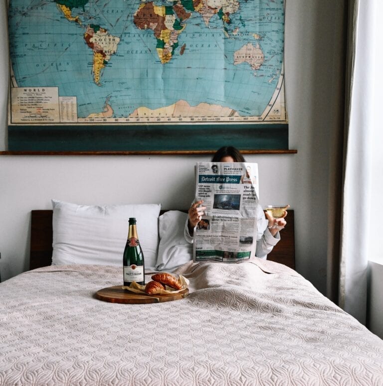 Reading in bed with wine and travel map poster