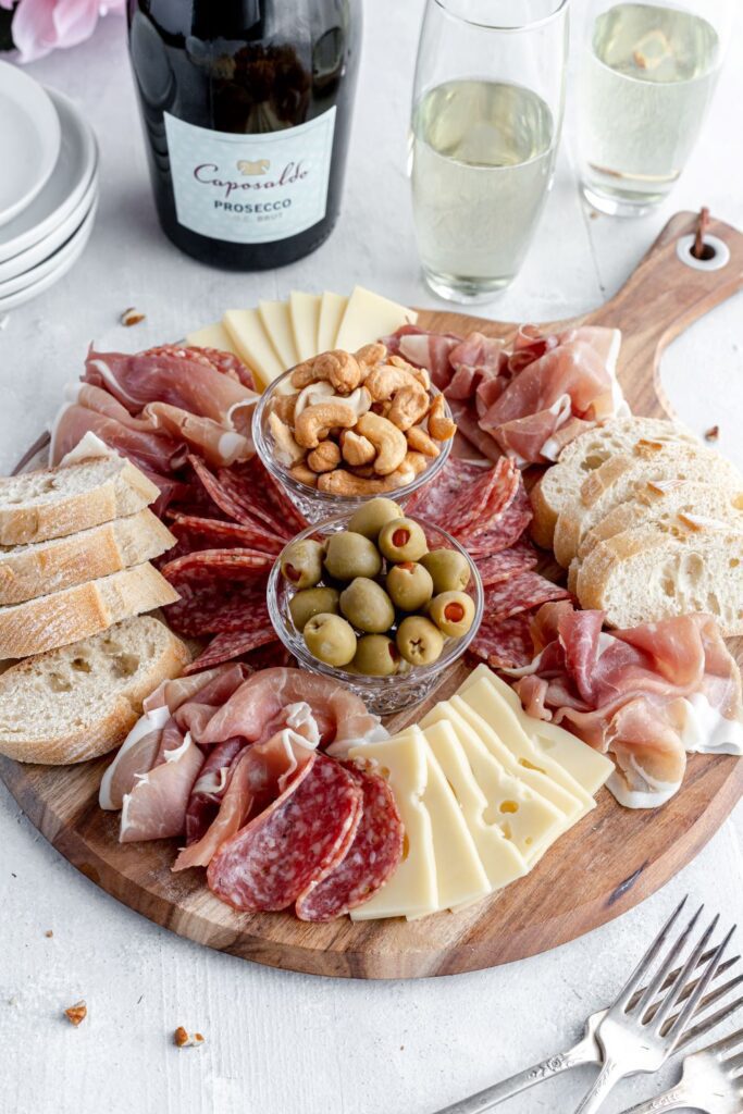 Charcuterie Board with Meat, cheese, bread and olives with caposaldo wine