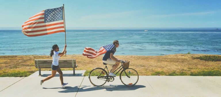 Running and biking with American flags by the ocean for Fourth of July