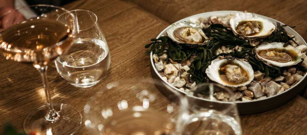 Oysters and white wine on table