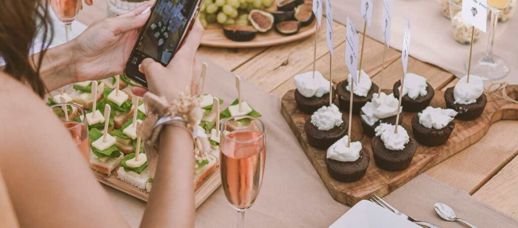 Autumn table setting with Champagne and girl holding smart phone