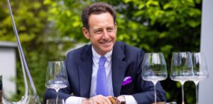 Riedel Crystal ceo and president Max Riedel sitting at a table with WineWings stemware glasses and wine decanter